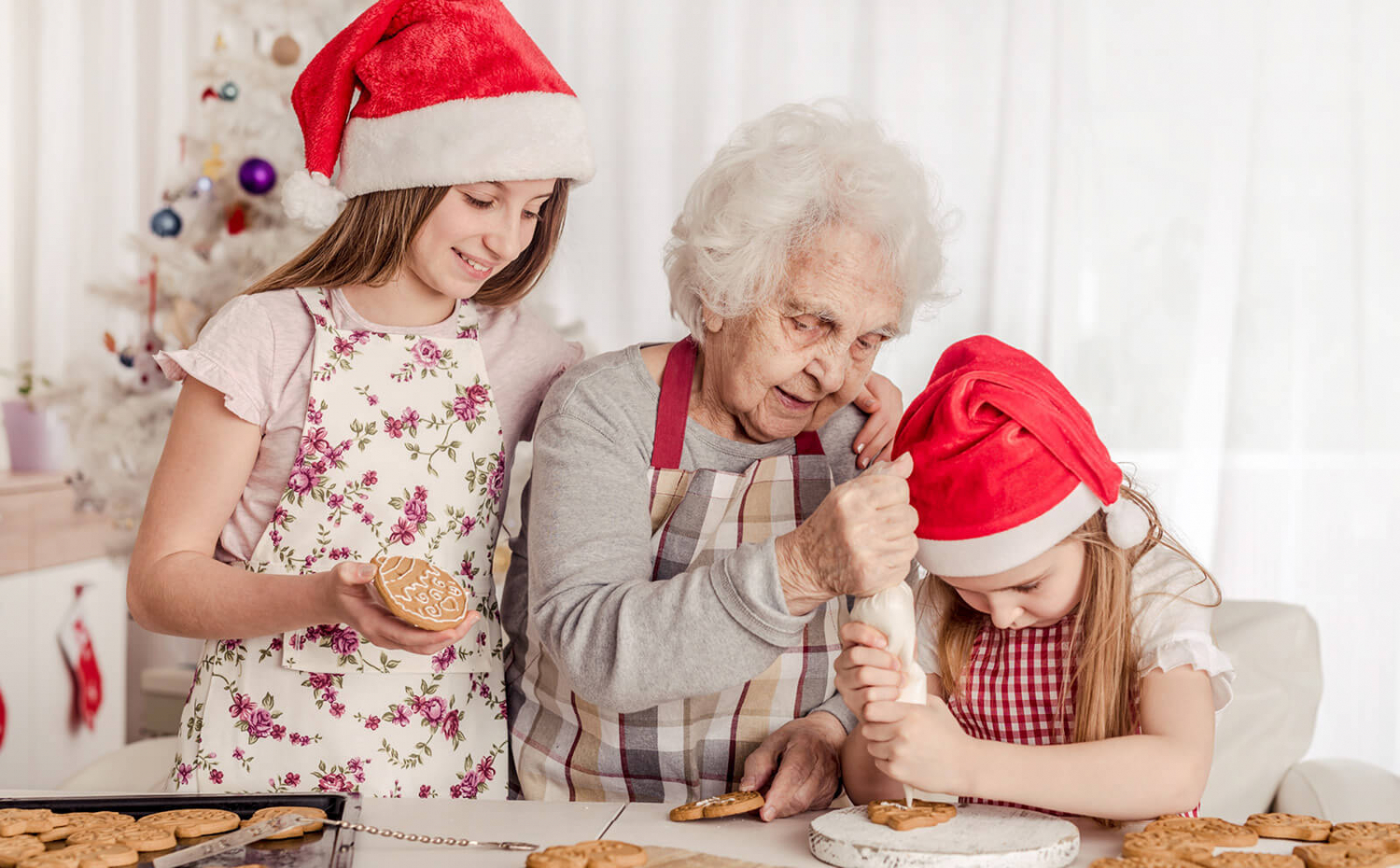 A grandmother decorating cookies with her granddaughters.